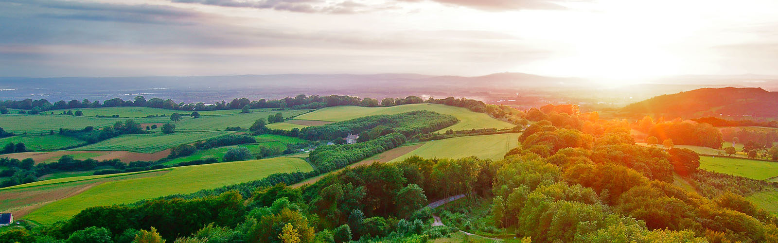 Sunset, with lens flare, in summer looking towards the Royal Forest of Dean from Painswick Beacon