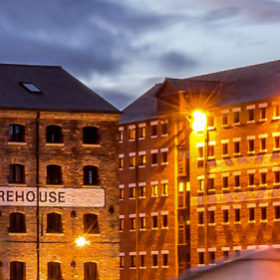 Gloucester docks with old warehouse at night.